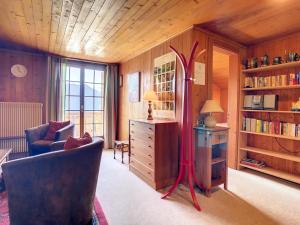 ein Wohnzimmer mit einem Stuhl und einem Schreibtisch mit einer Lampe in der Unterkunft Gavroche Combles in Verbier