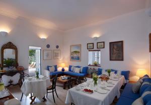 a living room with tables and blue couches at Orloff Boutique Hotel in Hydra