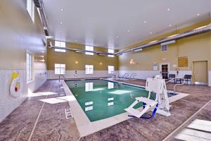 a pool in a large room with a gym with a swimming pool at Candlewood Suites Harrisburg-Hershey, an IHG Hotel in Harrisburg