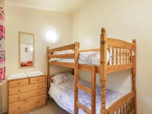 um quarto com 2 beliches e um espelho em The Log Cabin em Honiton