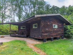 uma cabana de madeira com um telhado inclinado em The Log Cabin em Honiton