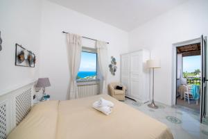 a bedroom with a bed with a view of the ocean at Hotel Villa Melodie - Adults Only in Ischia