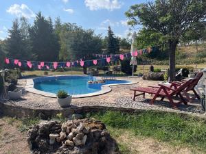 una piscina en un patio con una mesa de picnic y banderas en LakePark Garden Villa, en Bekecs