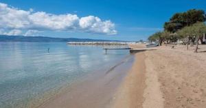 uma praia de areia com um barco na água em Apartments Kadenca em Omiš