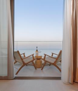 a room with two chairs and a table in front of a window at KALES SEA VIEW SUITES in Ierápetra