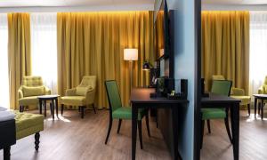a hotel room with yellow curtains and a desk and chairs at Thon Hotel Linne in Oslo