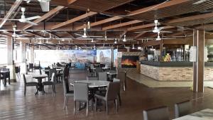 バトゥ・フェリンギにあるD'Feringghi Hotelのテーブルと椅子とバーのあるレストラン