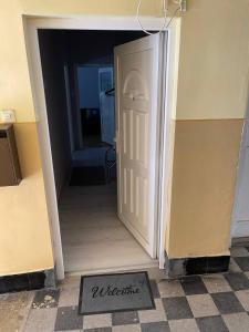 a door leading into a hallway with a welcome mat at Downtown Apartman near City Center & Miskolc Plaza in Miskolc