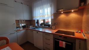a kitchen with white cabinets and a sink and a window at Apartma Lah in Kobarid