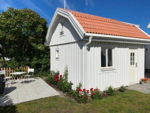 a small white building with a red roof at Attefallshus på Ängö i Kalmar in Kalmar