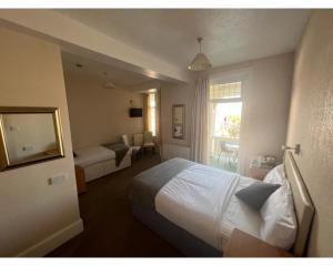 um quarto de hotel com uma cama e uma janela em Bonair Hotel em Paignton