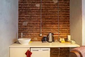 a kitchen counter with a sink and a brick wall at Classy Furnished Studio in The Heart of Karaköy ( Karakoy 1 ) in Istanbul