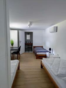 1 dormitorio con 2 camas, escritorio y mesa en Winnica NOVI - apartamenty, 