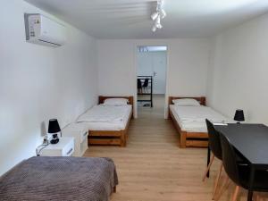 Habitación con 2 camas y mesa. en Winnica NOVI - apartamenty, 