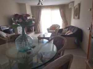 un salon avec une table en verre et un vase de fleurs dans l'établissement Appartment Kristal Mar II, à Moraira