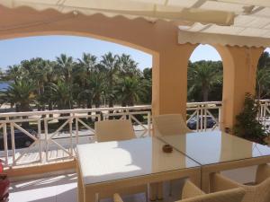 balcón con mesa, sillas y palmeras en Appartment Kristal Mar II, en Moraira