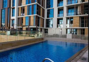 a large swimming pool in front of a building at Hometown Apartments - Brand New 2BR Apartment in Dubai Wharf 2 in Dubai
