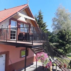 a house with a staircase and a balcony at Apartament nad wodą in Marzęcino +13 photos
