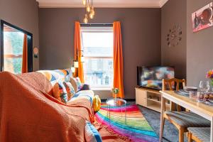 a living room with a colorful couch and a tv at Art-Filled Bohemian 1 Bedroom Apt 2 Beds Colourful Praise Inn Apartment in Hull