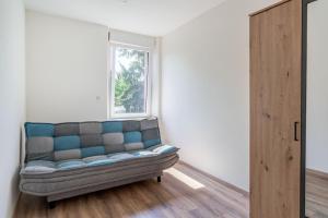 ein Sofa in einem Zimmer mit Fenster in der Unterkunft Gemütlich 4 in Wissembourg