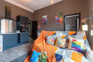 a living room with a couch with colorful pillows at Art-Filled Bohemian 1 Bedroom Apt 2 Beds Colourful Praise Inn Apartment in Hull