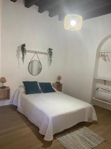 a bedroom with a large white bed with blue pillows at LA VENDIMIA in Jerez de la Frontera