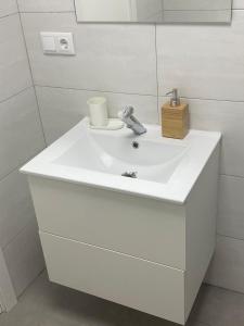 lavabo blanco en el baño con espejo en LA VENDIMIA, en Jerez de la Frontera