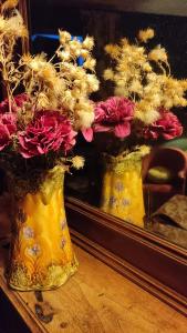 a yellow vase filled with flowers on a table at Suite Provençale in Saignon