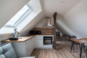 a kitchen and dining room in a loft with a window at Gemütlich 7 - Appartement cosy climatisé in Wissembourg