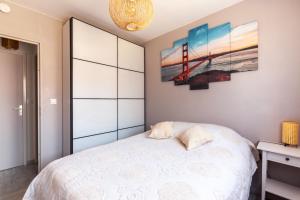 una camera da letto con un letto e un dipinto sul muro di Le Golden Gate a Cabourg