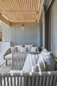 a group of beds on a porch with a wooden ceiling at Samphire Rottnest in Rottnest Island