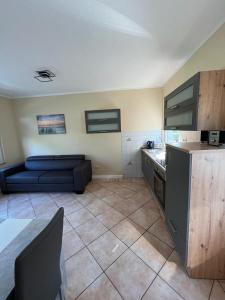 a kitchen with a blue couch in a room at Ferienbungalow Zum Anleger 3 in Hohenkirchen