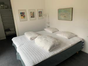 a bedroom with a bed with white sheets and pillows at Stugcentralen F-16B in Halmstad