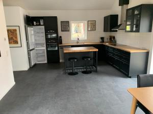 a kitchen with black cabinets and stainless steel appliances at Stugcentralen F-16B in Halmstad