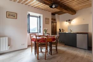 a kitchen and dining room with a table and chairs at Lou Baoumoun in Coursegoules