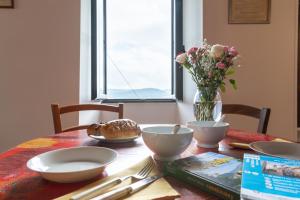 a table with plates and bowls and a vase of flowers at Lou Baoumoun in Coursegoules +4 photos