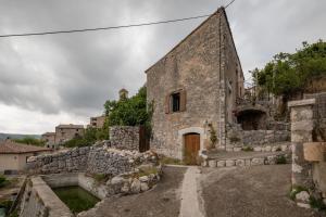 an old stone building with a stone wall at Lou Baoumoun in Coursegoules