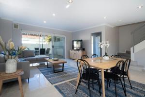 jadalnia i salon ze stołem i krzesłami w obiekcie 30 Rich On Richmond Modern Family Home 6 w mieście Perth