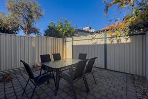 patio ze stołem, krzesłami i ogrodzeniem w obiekcie 30 Rich On Richmond Modern Family Home 6 w mieście Perth