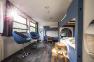 a bedroom with a bunk bed and blue chairs at Schiffsherberge Pöppelmann in Dresden