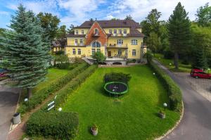 an aerial view of a large yellow house with a green lawn at Halny Pensjonat in Zakopane