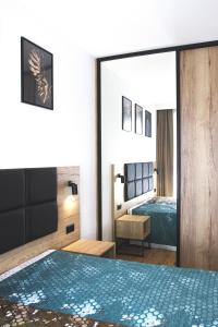 sypialnia z łóżkiem i dużym lustrem w obiekcie Apartamenty pod Szyndzielnią Enduro&Ski w Bielsku Białej