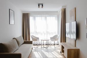a living room with a couch and chairs and a table at Apartament pod Szyndzielnią Enduro&Ski #nestapartamenty in Bielsko-Biała