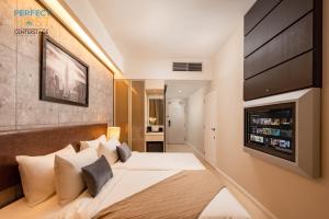 八打靈再也的住宿－Centrestage Petaling Jaya by Perfect Host，一间卧室配有一张大床和一台平面电视