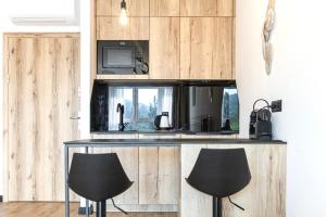 a kitchen with two black chairs and a counter at Apartament pod Szyndzielnią Enduro&Ski #nestapartamenty in Bielsko-Biała