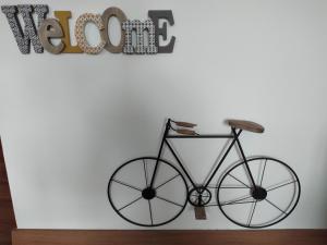 un vélo suspendu sur un mur à côté d'un panneau dans l'établissement Appartamento a due passi da Burcina, à Favaro