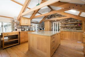 a kitchen with wooden cabinets and a stone wall at Honeycrisp Barn in Newquay
