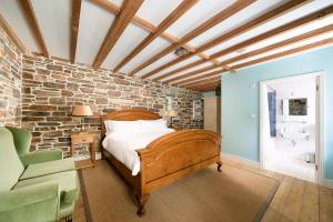 a bedroom with a bed and a brick wall at Honeycrisp Barn in Newquay