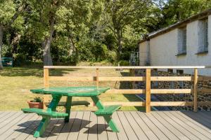 a picnic table and two benches on a deck at Honeycrisp Barn in Newquay