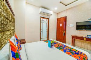 1 dormitorio con 1 cama y TV en la pared en FabHotel Eleven Heights en Bhopal